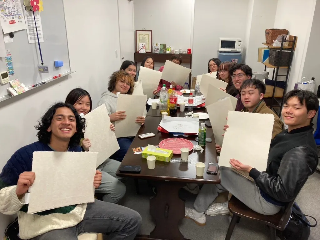 Group showing their handmade paper sheets